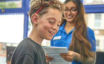 A close up on the face of a teenage child with a tutor.