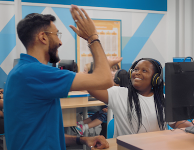 An Explore Learning Tutor high fiving with a child in a centre